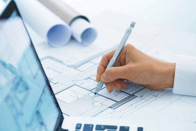 Main dessinant sur un plan de logement